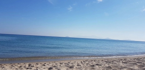 Sandy Kos beach with blue skies and calm sea