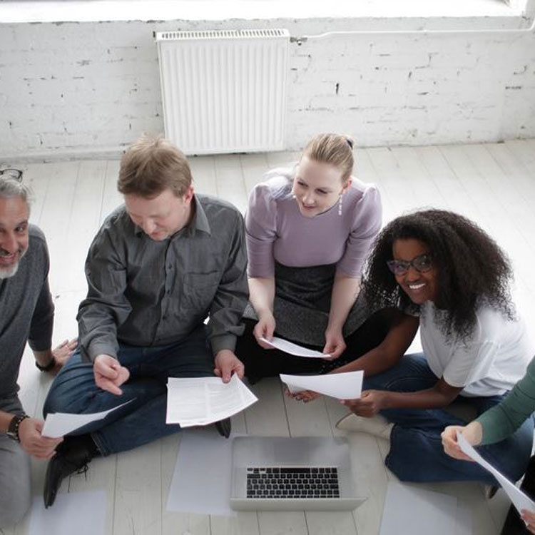 Group of people working around a laptop