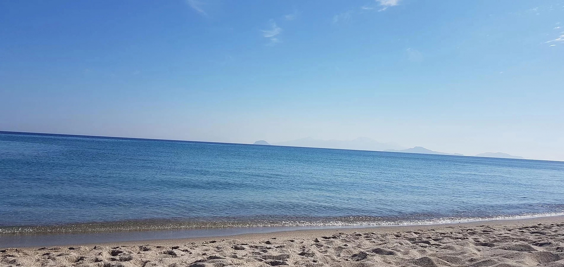 Sandy Kos beach with blue skies and calm sea